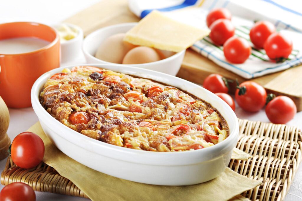 baked cherry tomatoes with melted cheese in oven dish